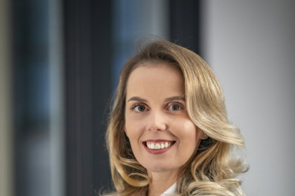 A woman in a business suit standing with her arms crossed